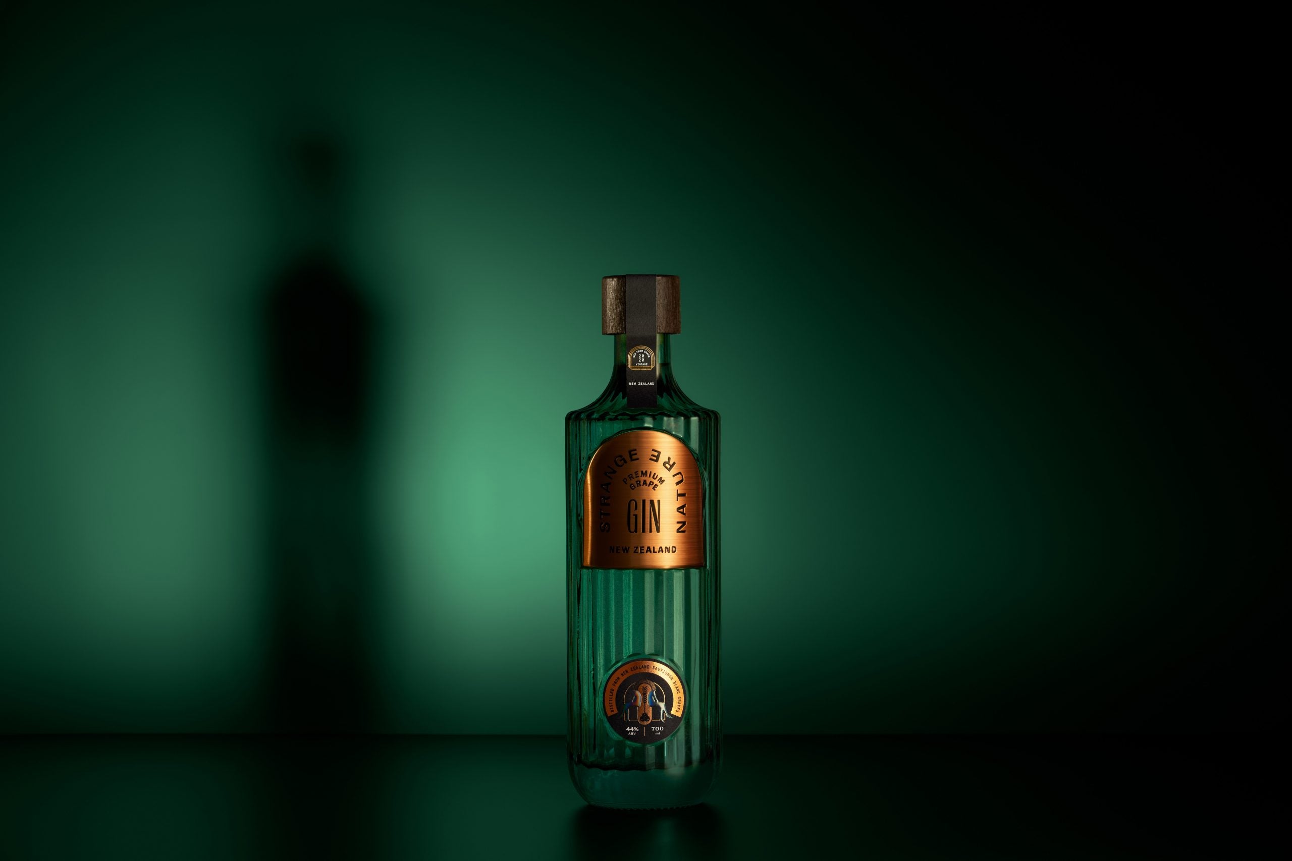 Green bottle with a gold label on a dark green background
