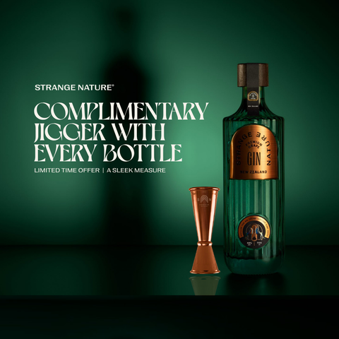 A bottle of Strange Nature Chilled Pure Gin with a copper jigger beside it on a dark green background, with promotional text reading 'Complimentary Jigger with Every Bottle'.